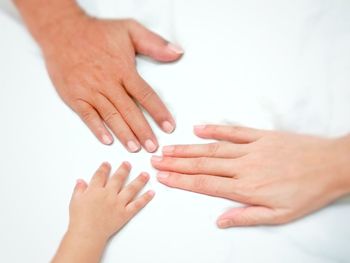 Close-up of hands over white background