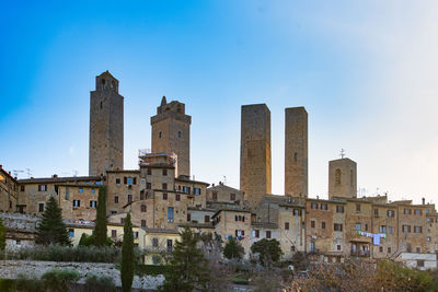 Buildings in city against clear blue sky