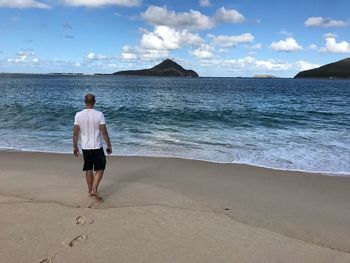 Rear view of man standing on beach