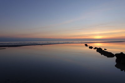 Scenic view of beach against sky during sunset