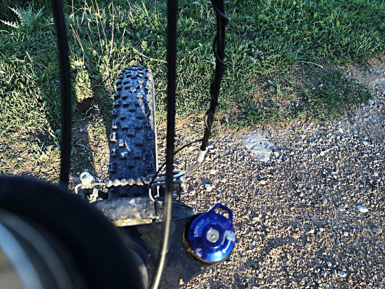 transportation, high angle view, mode of transport, shoe, metal, street, land vehicle, part of, low section, road, close-up, day, sunlight, outdoors, blue, footwear, bicycle, asphalt, person, car