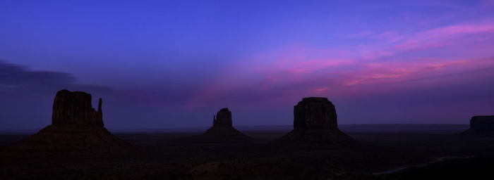 Scenic view of silhouette rocks against sky during sunset