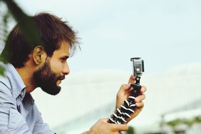 Close-up of man looking at mobile phone in monopod