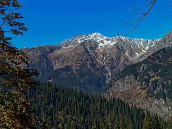 Scenic view of snowcapped mountains against clear blue sky