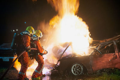 Firefighters extinguishing fire at night
