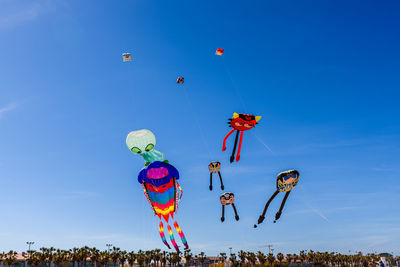 Low angle view of kite flying against blue sky