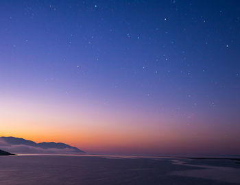 Scenic view of sea against clear sky at night