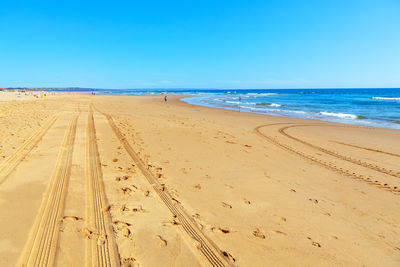 Atlantic ocean coastline in the summer day . tractor prints on the sandy beach