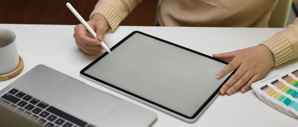 Midsection of woman using laptop on table