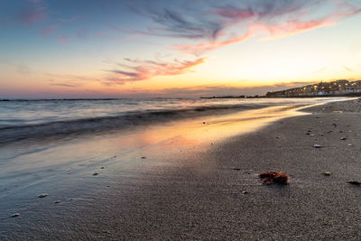 Scenic view of beach against sky during sunset