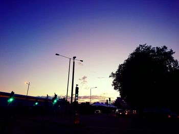 Illuminated street light against blue sky