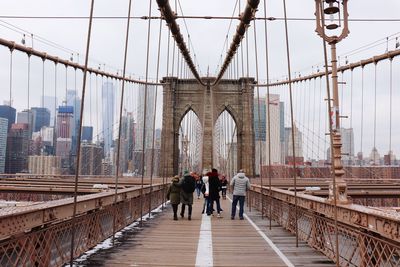 Rear view of people walking on suspension bridge