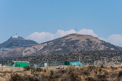 Scenic view of land and mountains against blue sky