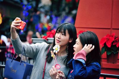 Portrait of smiling young woman using mobile phone