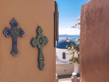 Crosses on brown wall at oia