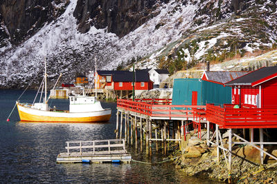 Sailboats moored on sea against buildings