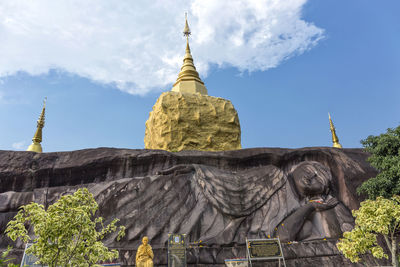 Low angle view of statues on building against sky