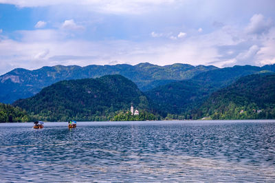 Scenic view of lake by mountains against sky