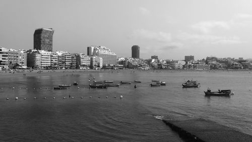 Boats in river with cityscape in background