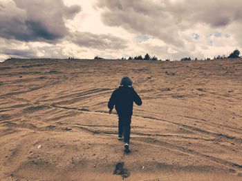 Rear view of kid walking on land