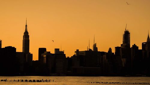 Silhouette of buildings in city during sunset