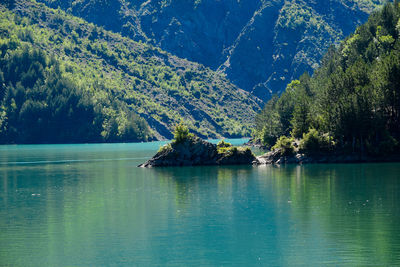 Scenic view of lake by trees against sky