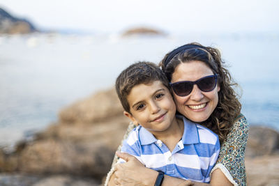 Portrait of smiling mother and son at beach