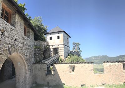 Low angle view of old building against clear blue sky