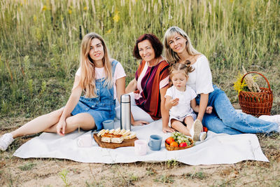 The family is having a picnic on the lawn. three generations of women of the same family 