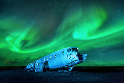 Wrecked military plane against northern lights