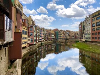 Reflection of buildings in canal against sky