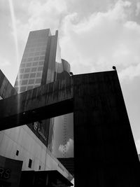 Low angle view of modern building against cloudy sky