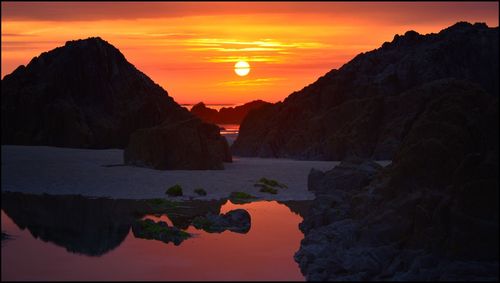 Scenic view of rock formation against romantic sky at sunset