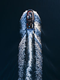 Directly above shot of ship in sea against black background