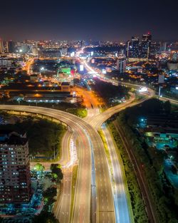 High angle view of illuminated street amidst buildings at night