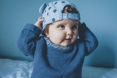 Cute girl looking away wearing cap at home