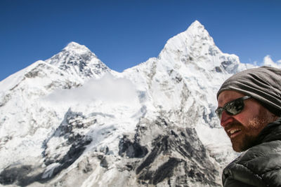 Low angle view of man against snowcapped mountains