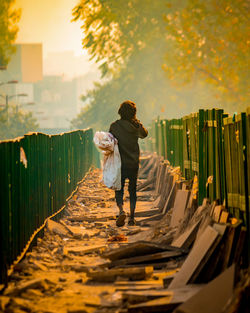 Rear view of man walking on footpath