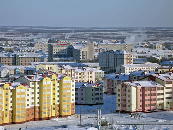 High angle view of buildings by sea against clear sky