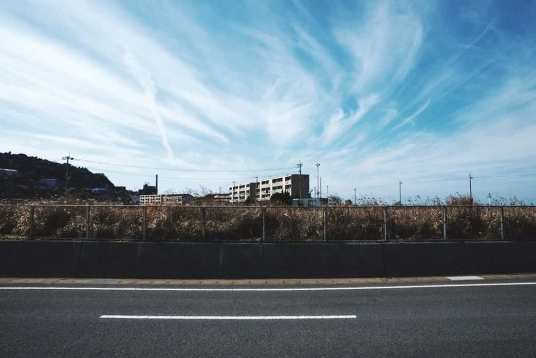 sky, road, transportation, architecture, built structure, road marking, building exterior, street, cloud - sky, connection, cloud, bridge - man made structure, city, blue, communication, outdoors, day, no people, asphalt, road sign