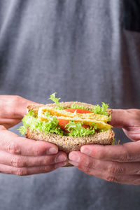 Midsection of man having sandwich