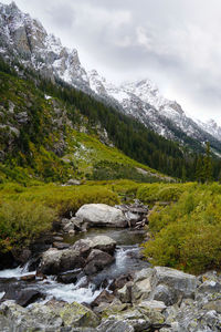 Scenic view of stream amidst rocks against sky