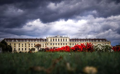 Building on field against cloudy sky