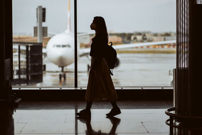 Side view of woman wearing mask walking at airport