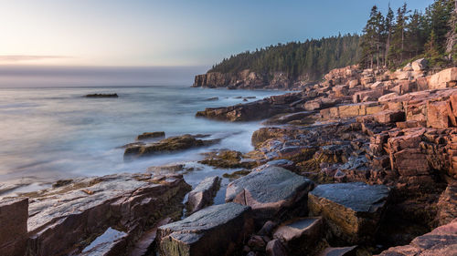 Scenic view of rocks on beach against sky