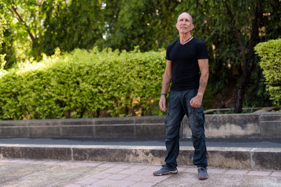Portrait of man standing on footpath