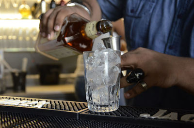 Midsection of bartender making drink