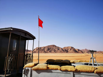 Flag on an old train at the wadi rum station in the desert against clear blue sky