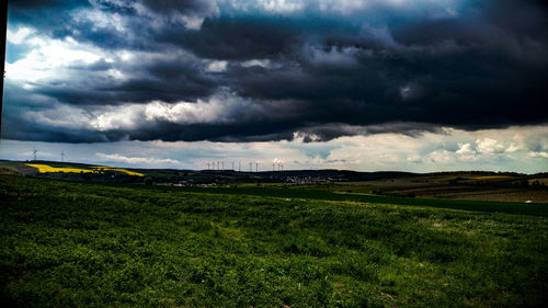 Scenic view of field against dramatic sky