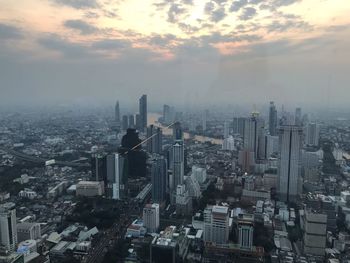 High angle view of modern buildings in city against sky during sunset